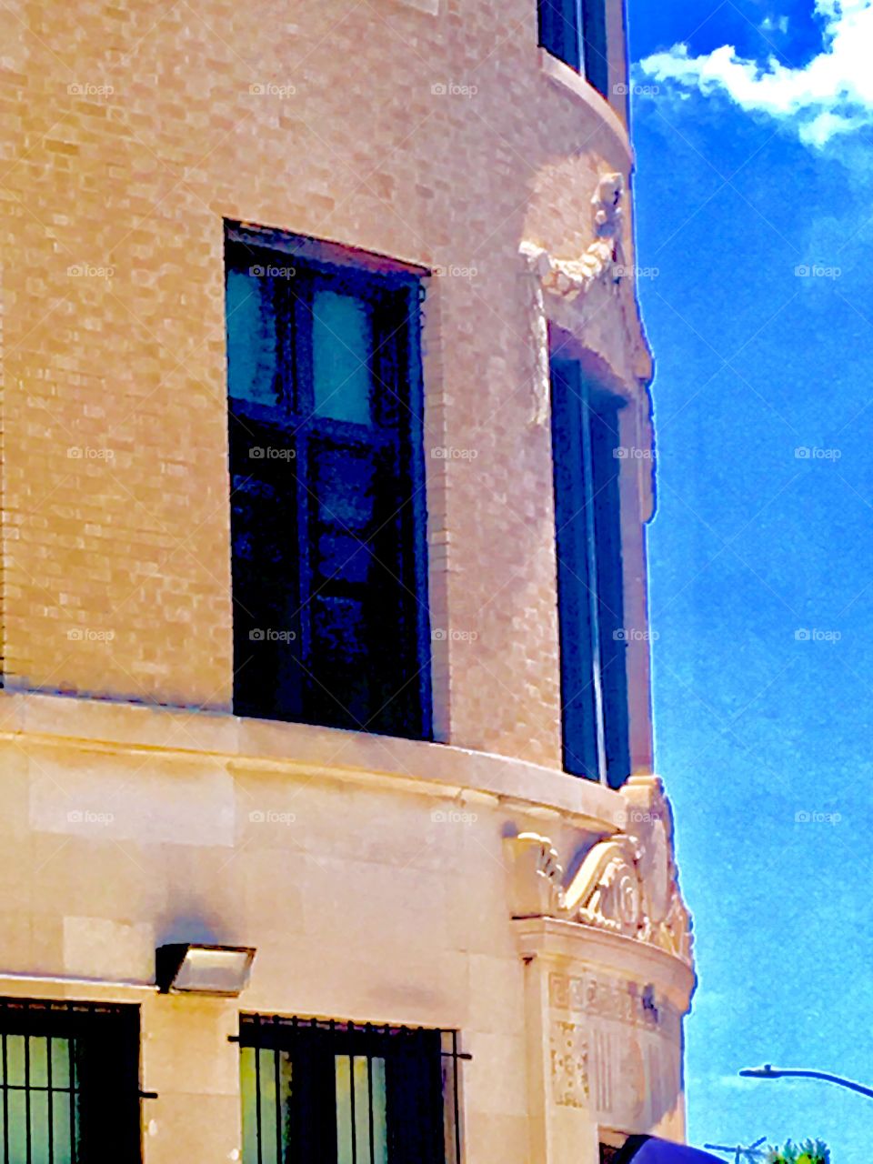 View of the sky and windows in a partially round building on Fulton Street in Brooklyn, New York in the early afternoon. This picture was taken in the summertime, the year was 2020. Hypnotic Productions
