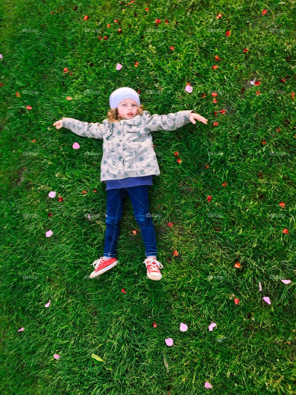  Cute girl dreaming laying on the grass.  