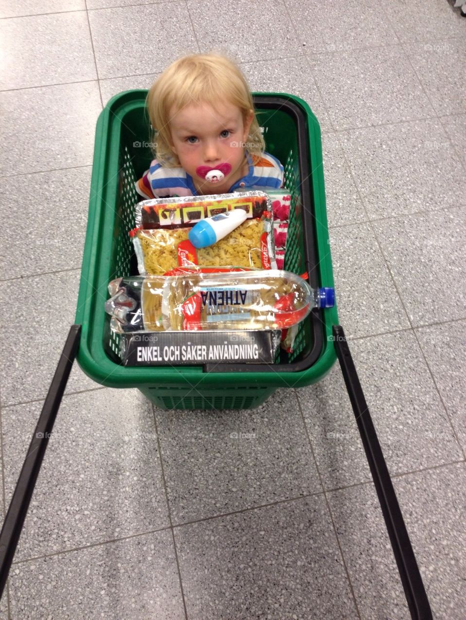 Three year old girl riding the shopping cart at a local store in