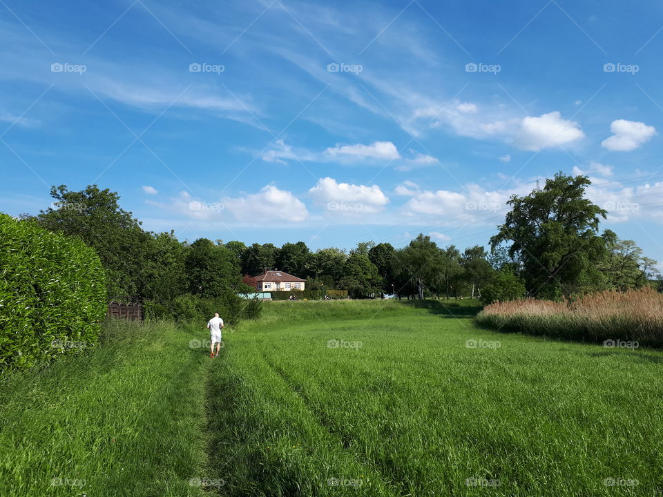 Man running outside. Outdoor activities. Man runs through the meadow