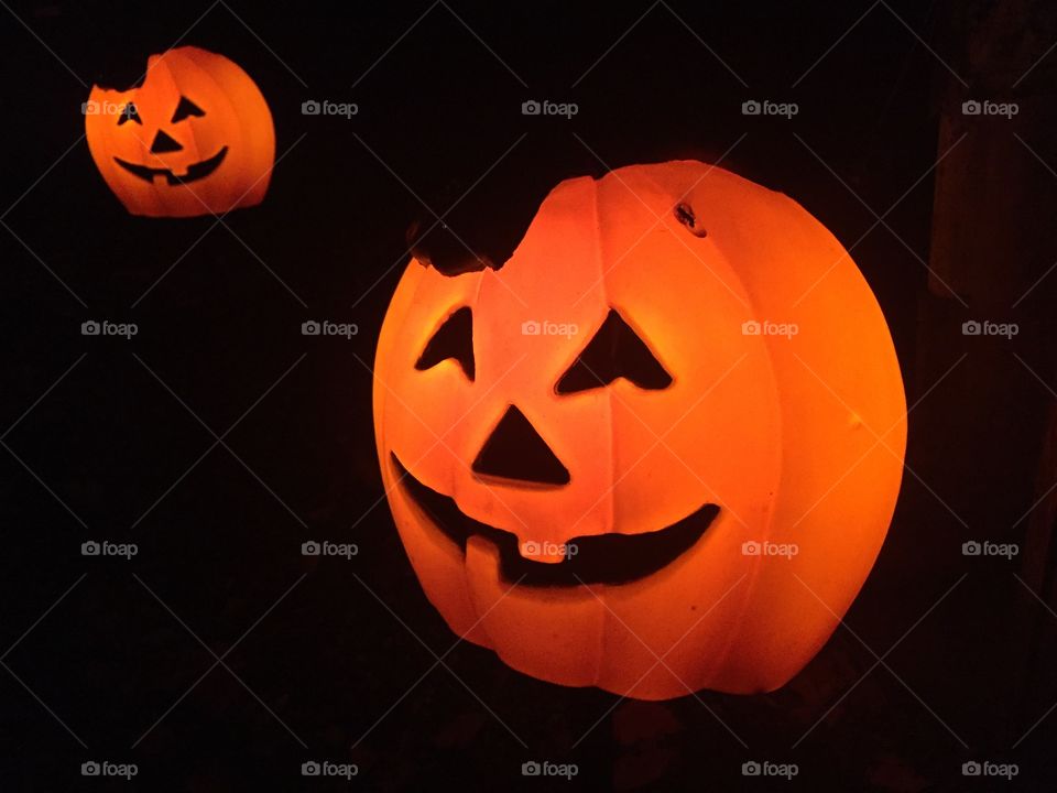 Two lit pumpkins on Halloween.