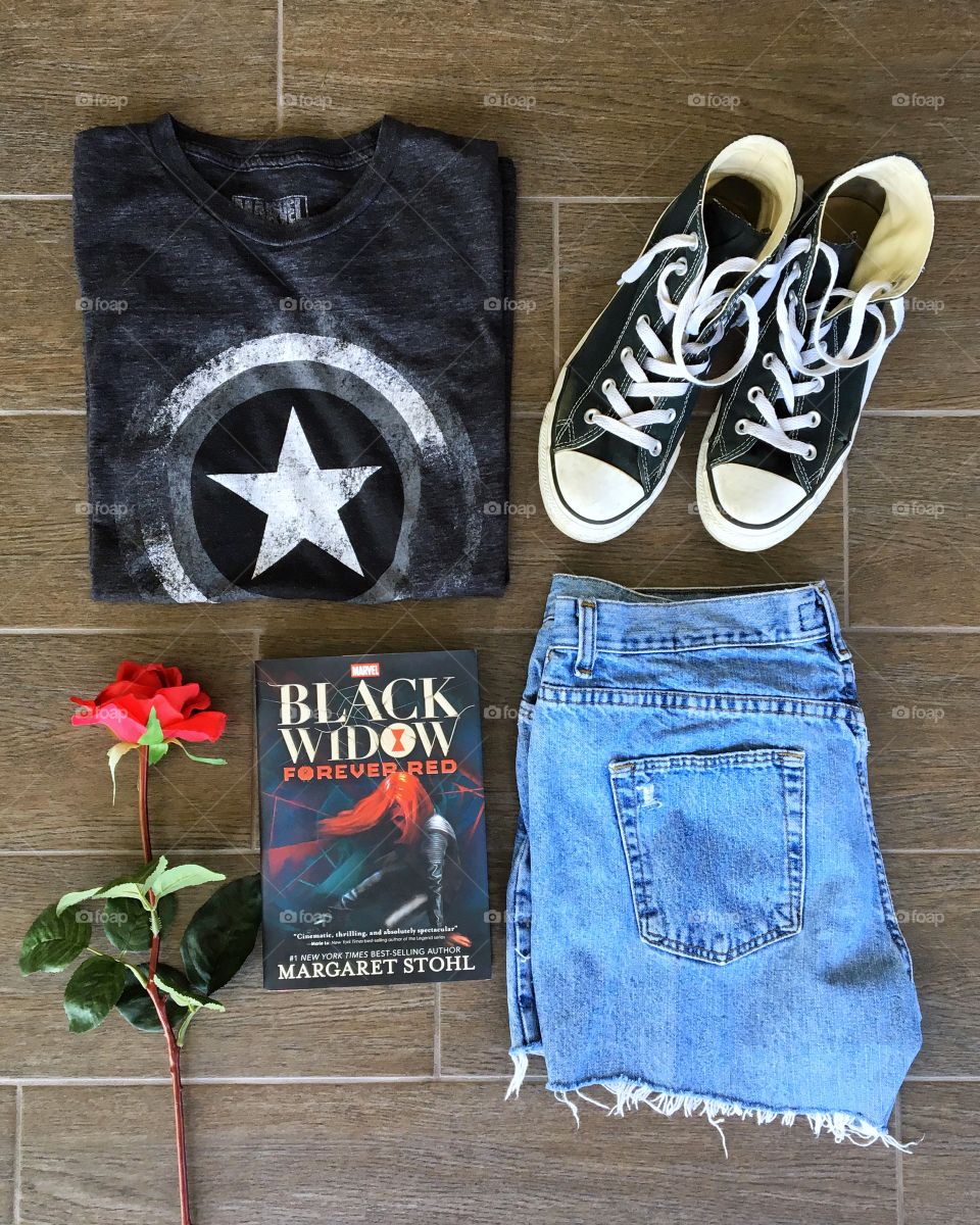 Superhero fashion flatlay with book and rose. 