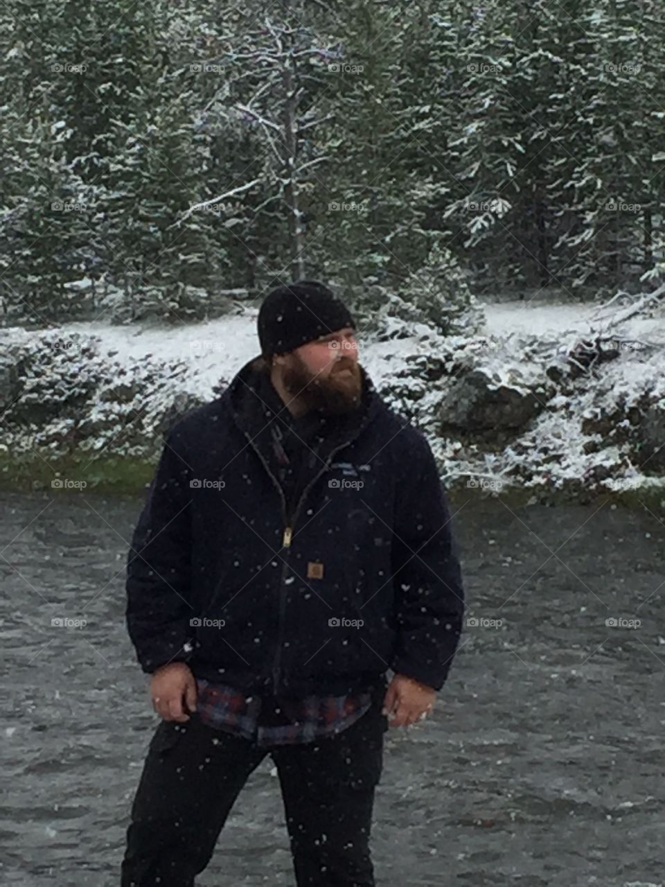 Man in snow by stream