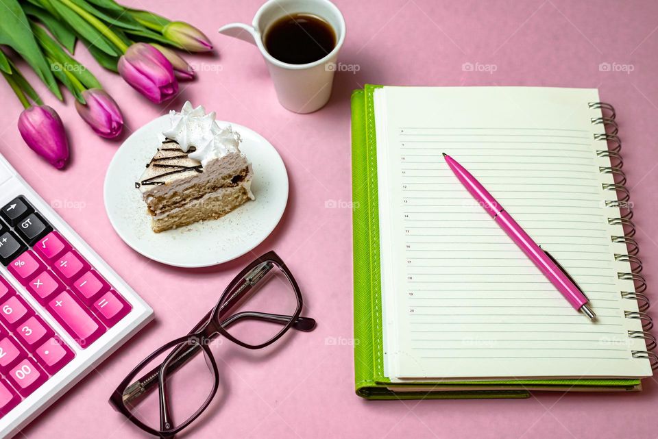 flat lay on pink background, notepad coffee and cake