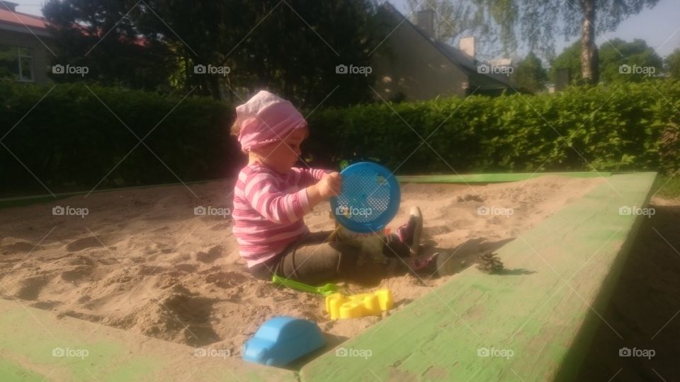 sandbox fun. cute toddler playing in sandbox