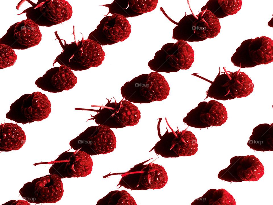 Raspberries in rows on a white background