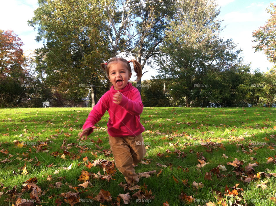 Little girl running and playing in the park.