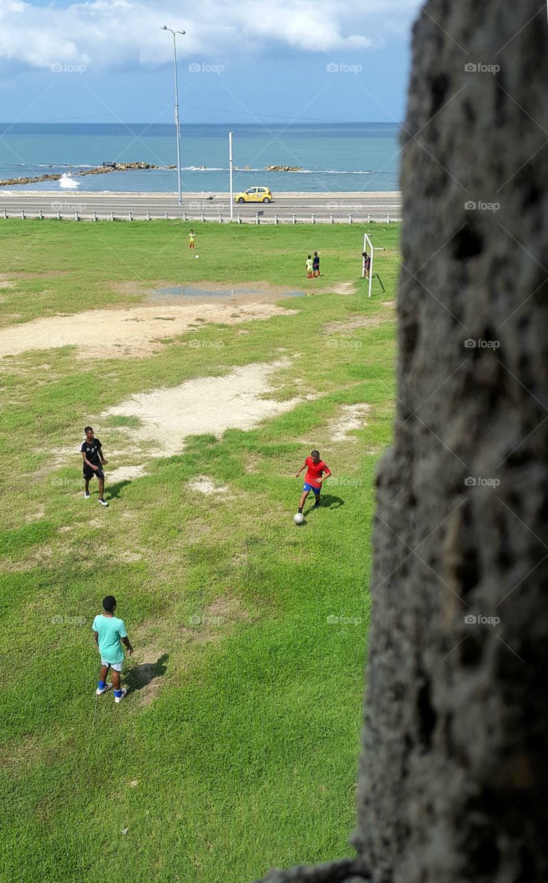 A view atop Cartagena's old city wall shows soccer players on the coast of Colombia.