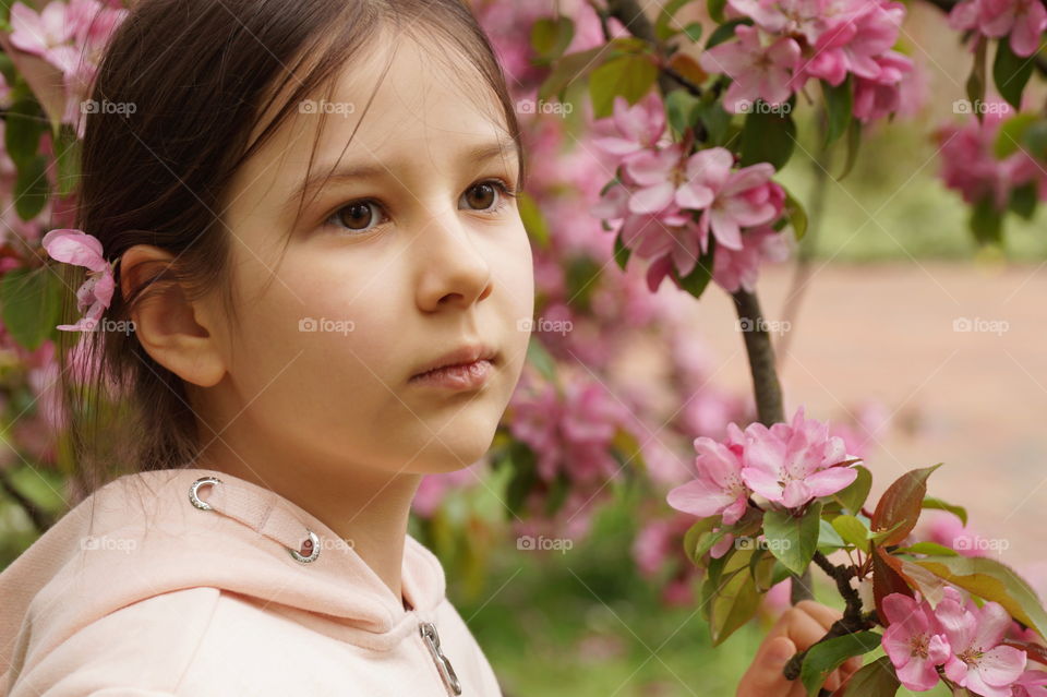 Girl with a blossoming rose tree