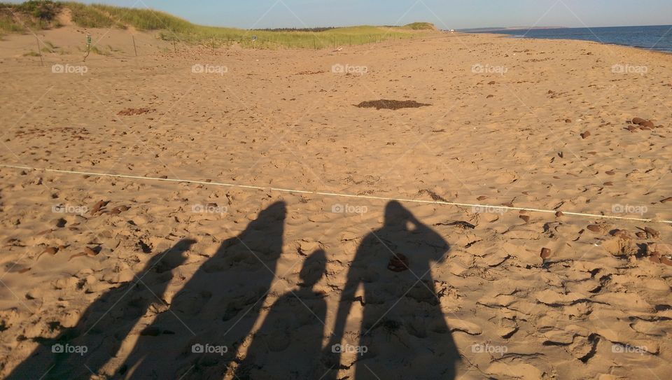 Silhouette of family of four (2 adults and 2 children) at a beach