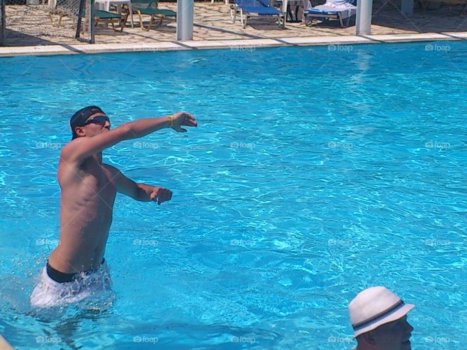 Shirtless man with sunglasses in swimming pool