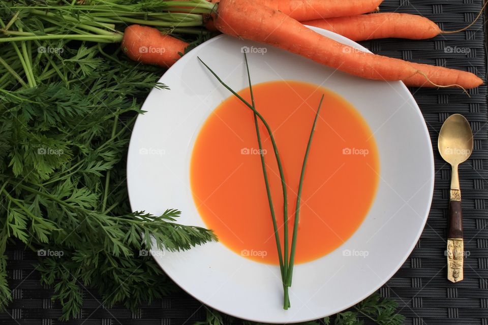 Fresh carrot soup garnished with chives with organic home grown carrots