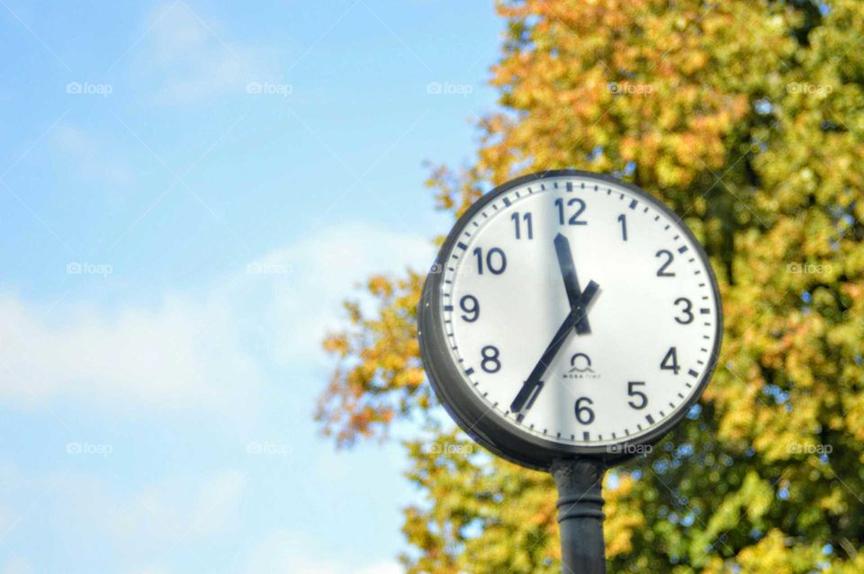 Street clock at autumn