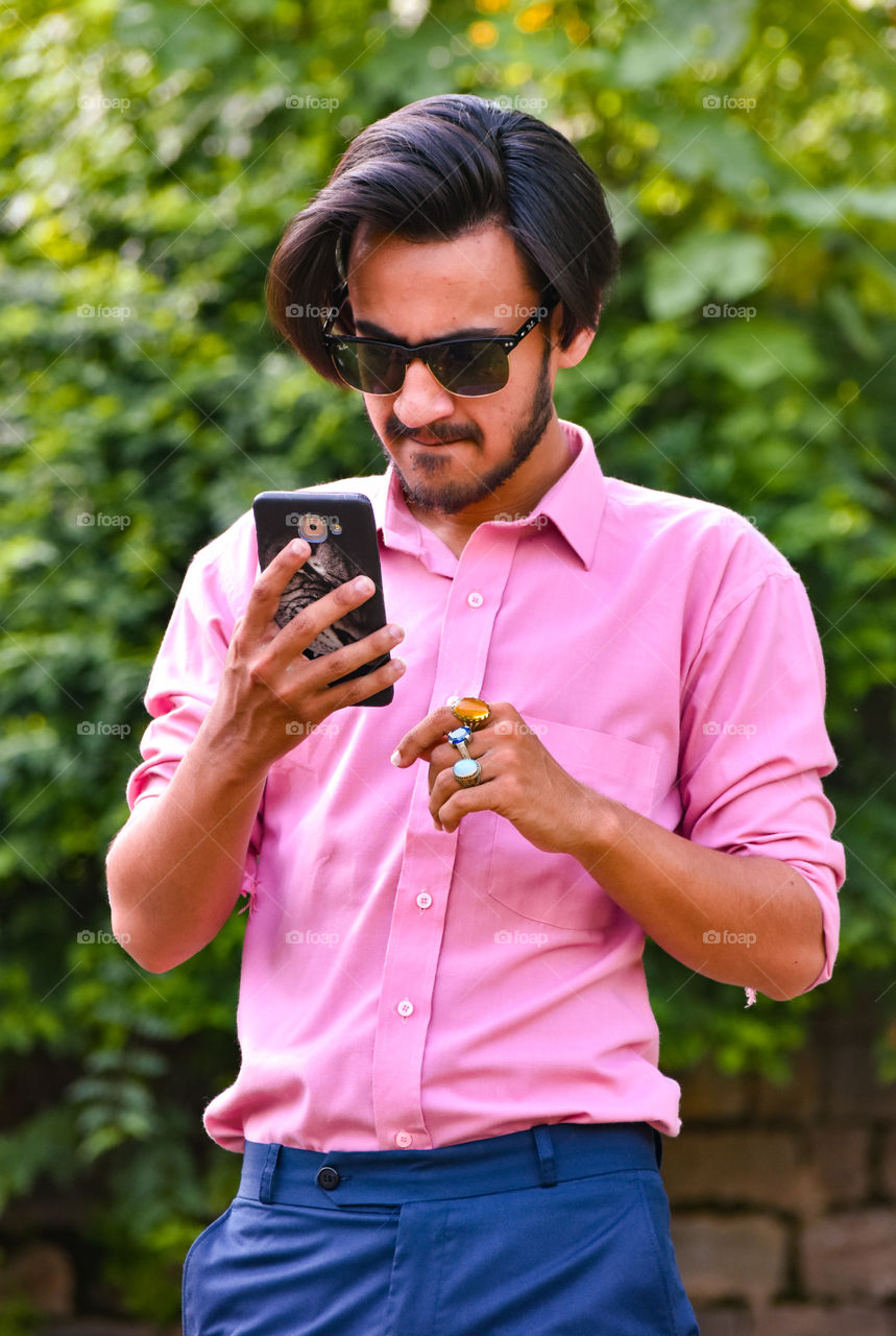 Young male model using mobile phone 