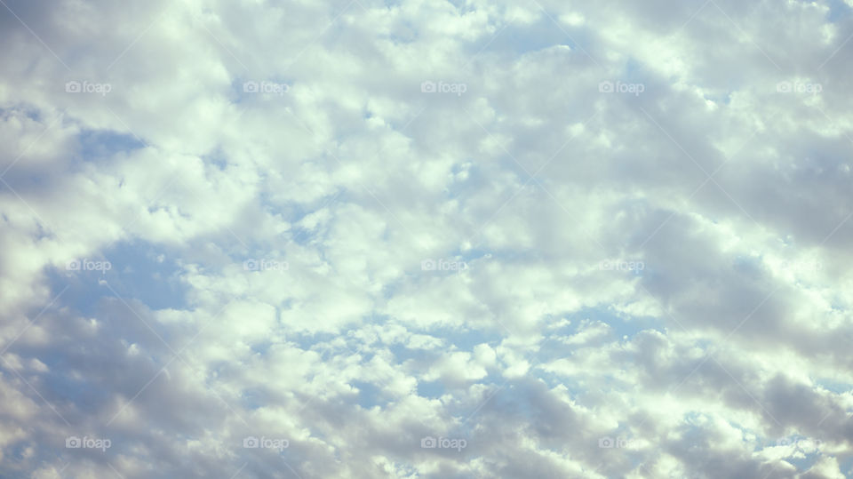 Large clouds float across the sunset sky like sails.