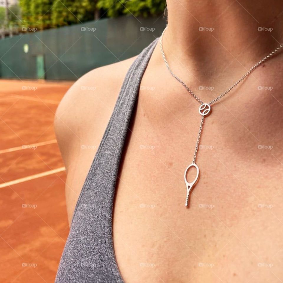 Woman wearing tennis racket pendant necklace