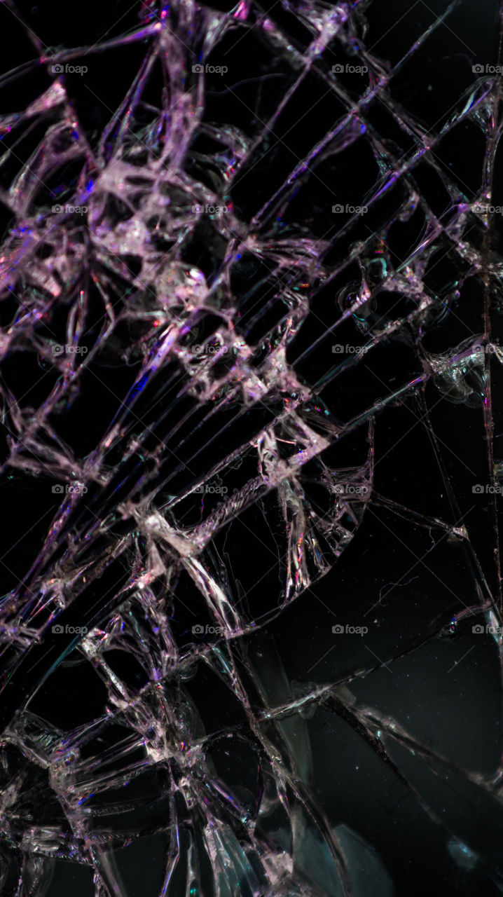 Multi-colored and bright broken smartphone screen close-up.