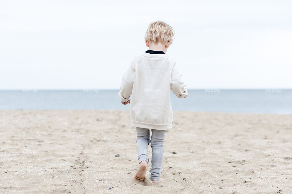 A young boy running on the beach