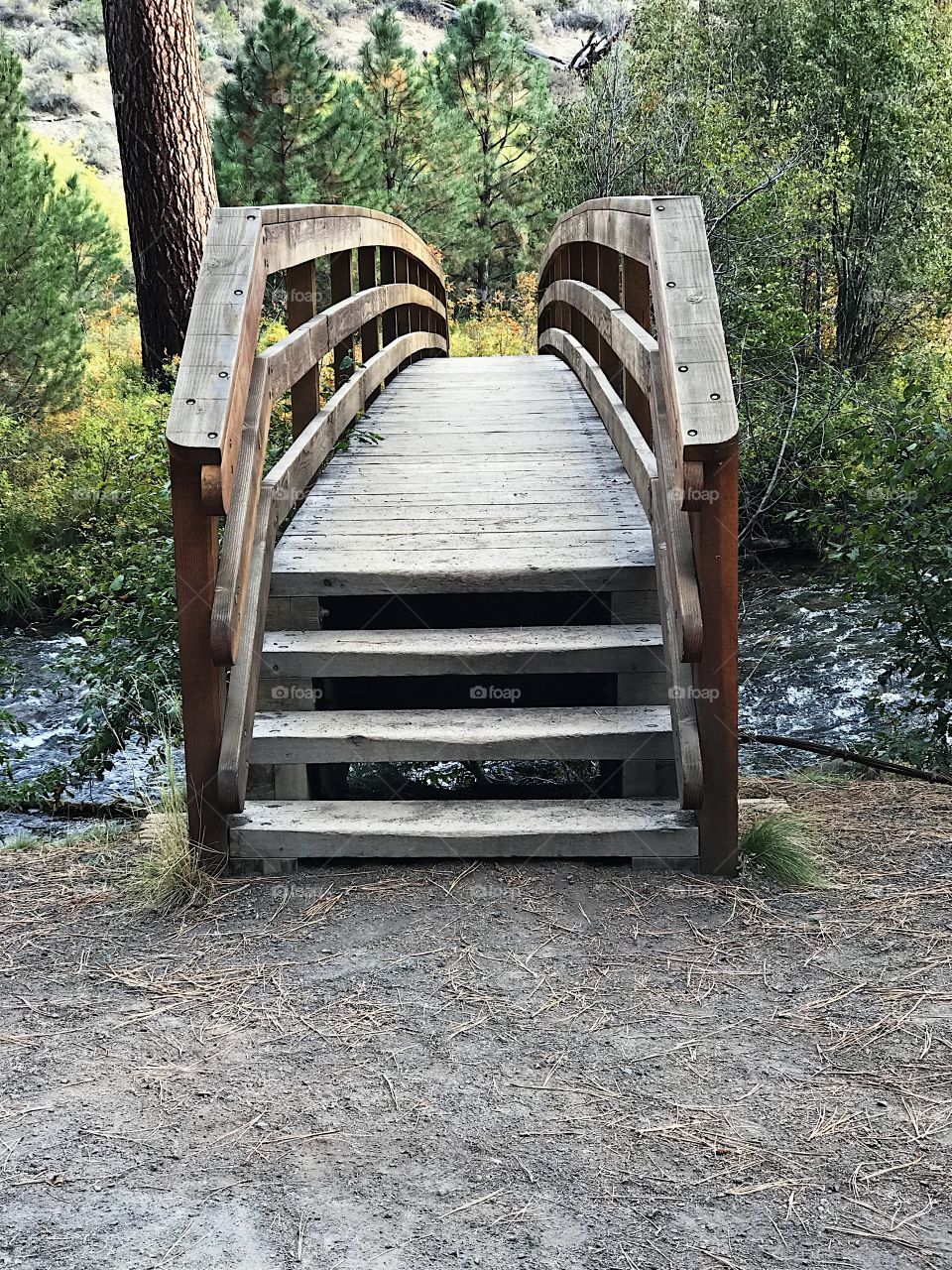 A wooden foot bridge crosses Tumalo Creek at Shevlin Park outside of Bend in Central Oregon. 