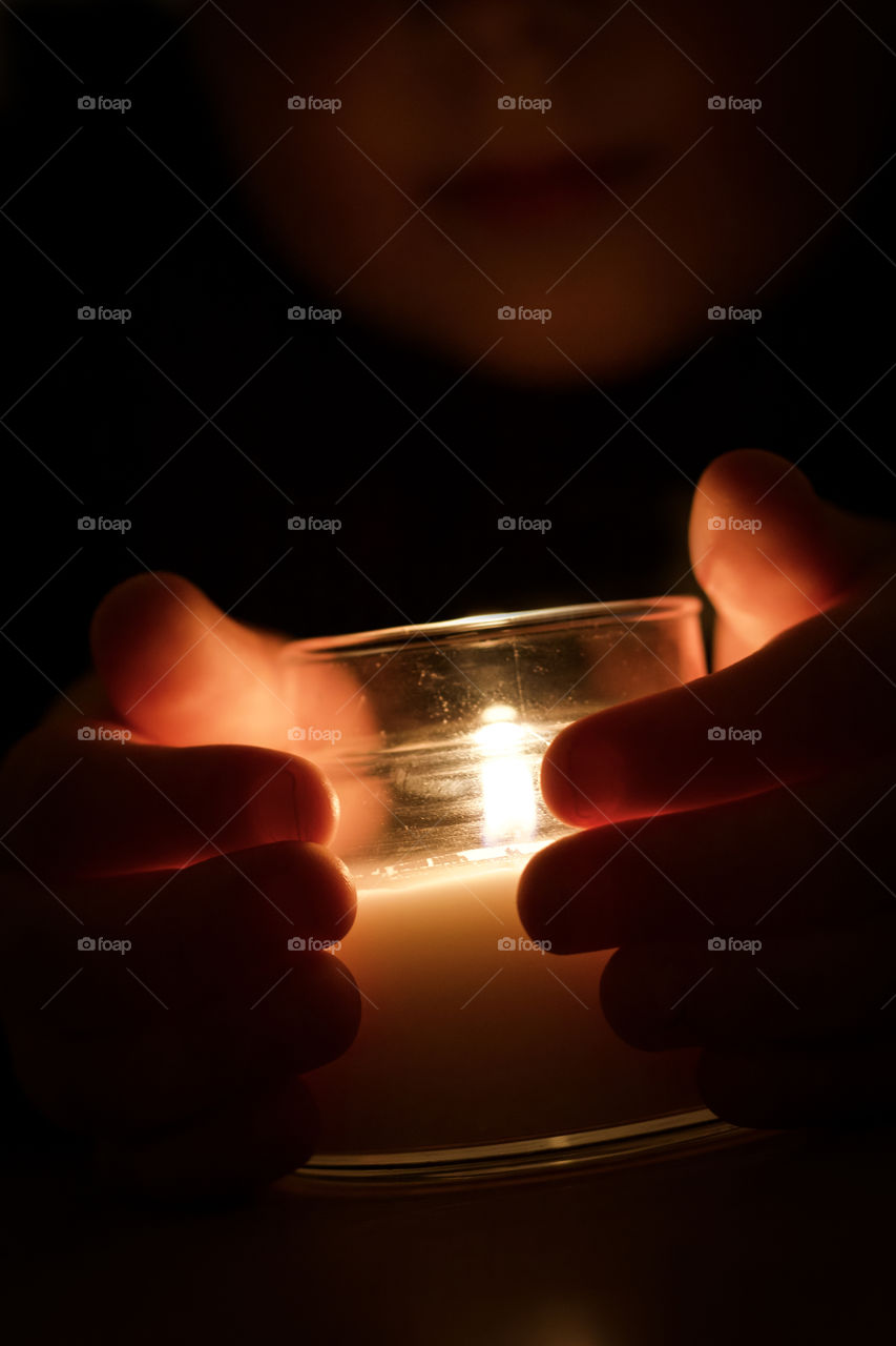 Hands round a candle