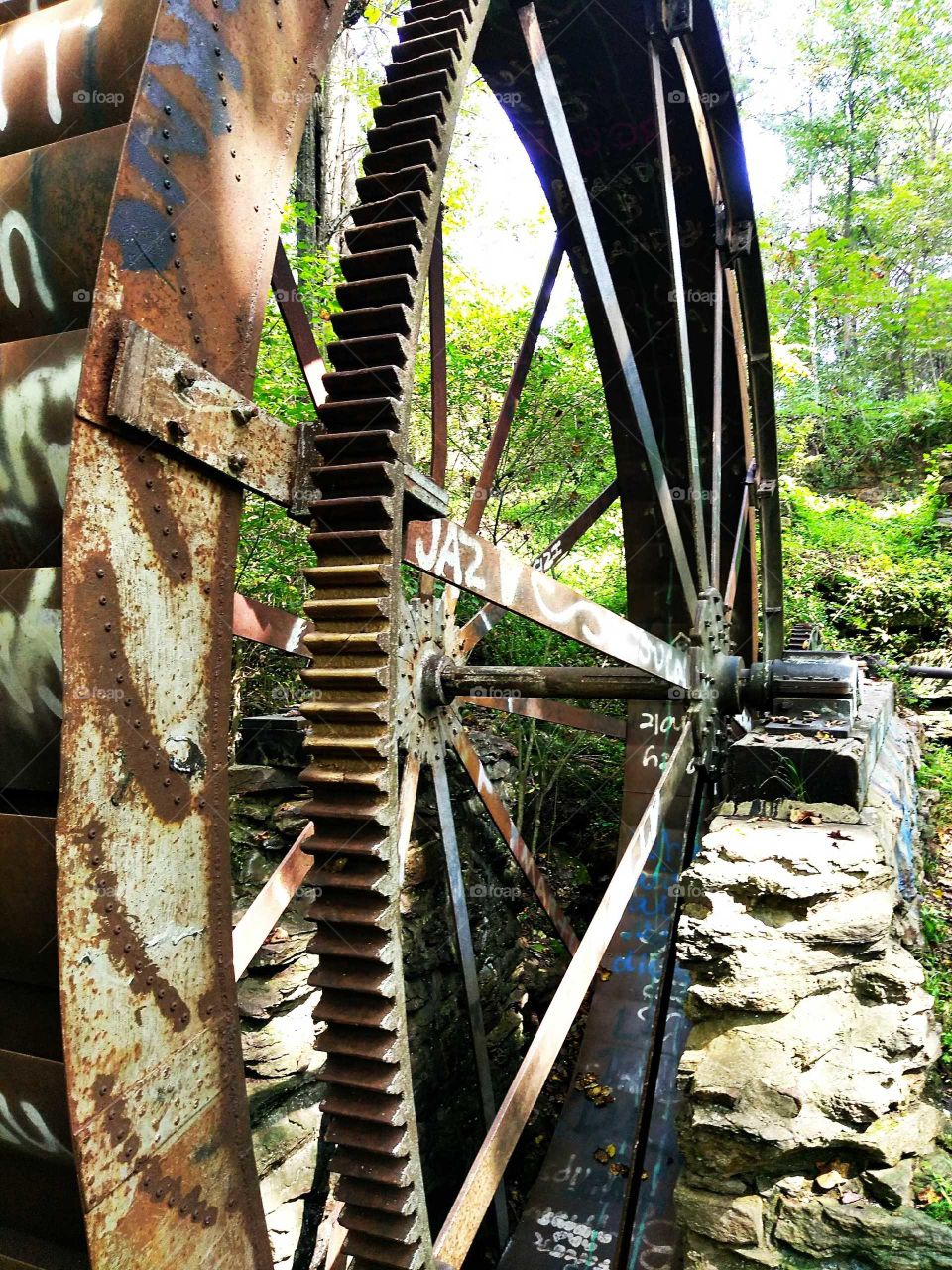 Old graffitied grist mill wheel
