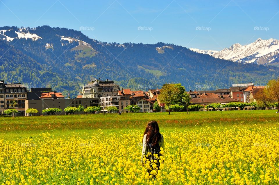 Girl standing in oilseed rape field