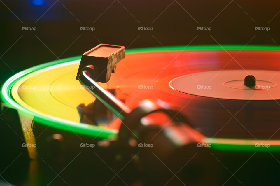 disk of an old loudspeaker in different colors long exposure photo with light trails dominated by red yellow and green