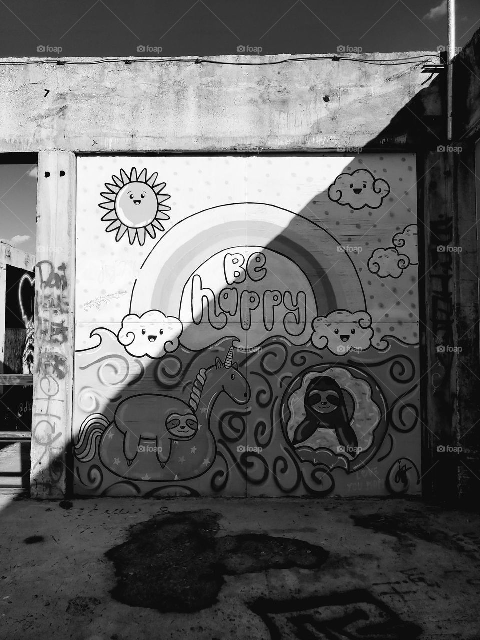 Abandoned outdoor art mural gallery piece that says be happy with childlike depictions but ironic because it looks really sad, dark and abndoned like a distant dream.