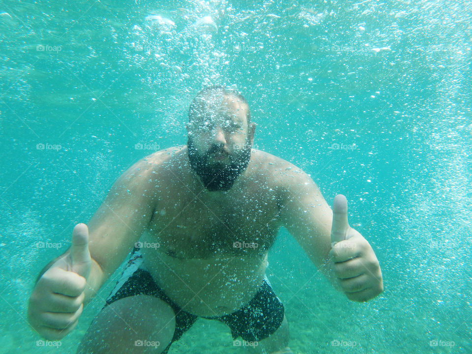 man pointing ok underwater. bearded man pointing ok underwater