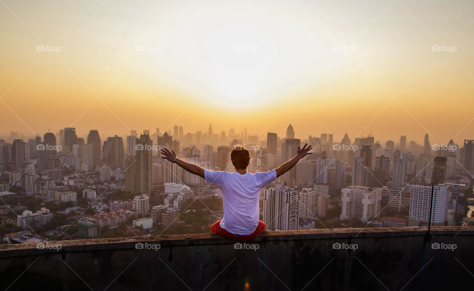 Rear view of a man enjoying the view of cityscape