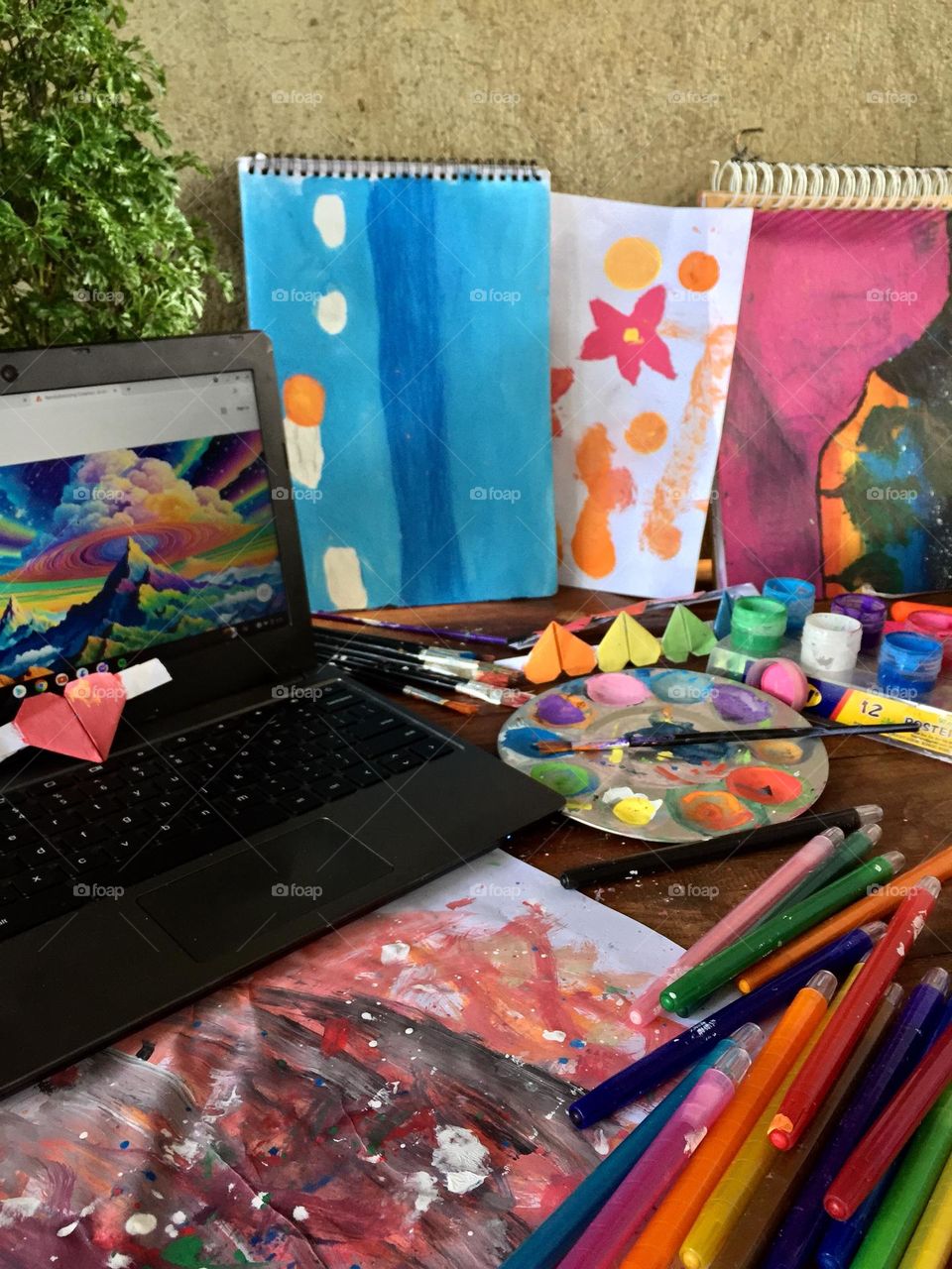 A colourful table full of art materials for paintings and learning.