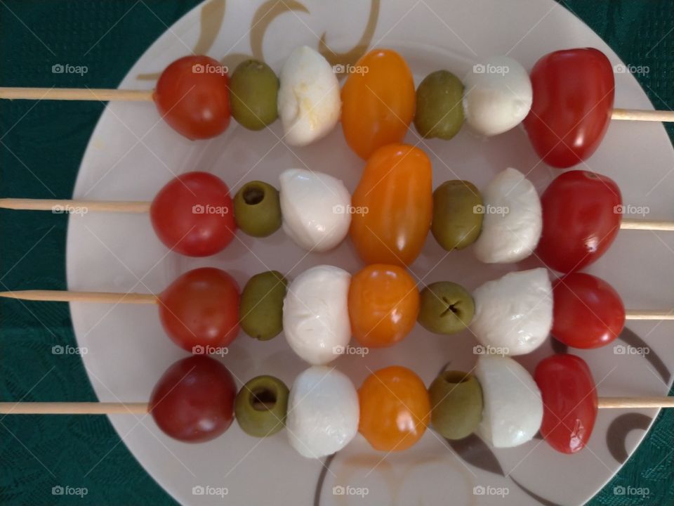 Closeup of cocktail, tomatoes, olives, mozzarella