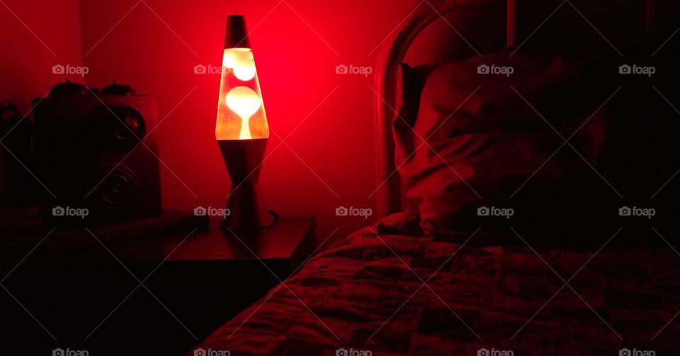 Red Lava lamp on a bedside table with antique phone