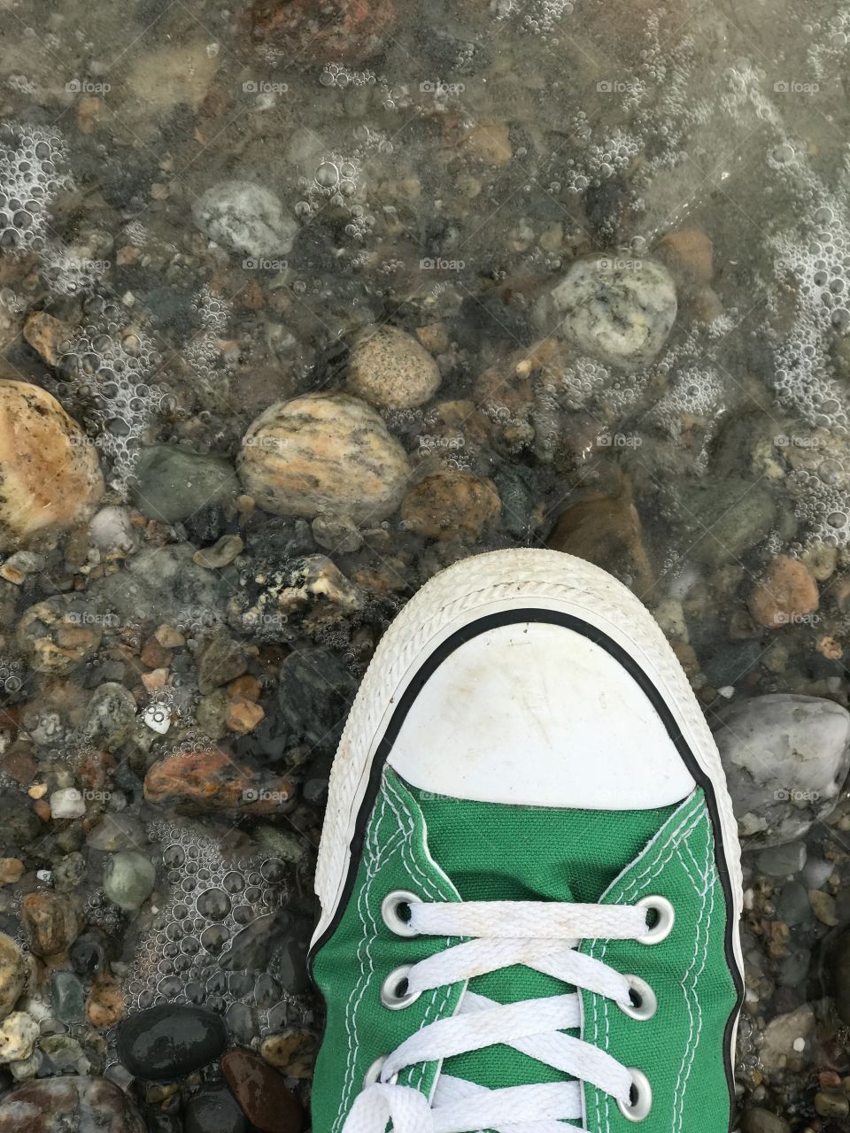 Converse shoe with ocean waves crashing to the shore