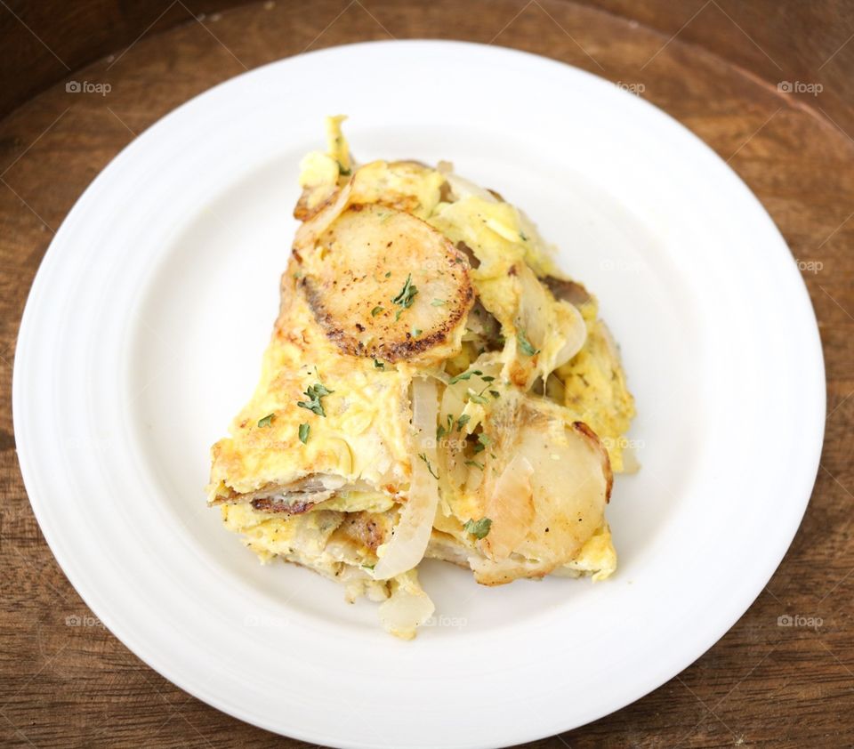 Spanish omelet. thinly sliced crispy potatoes and onions cooked in garlic oil and sprinkled with parsley