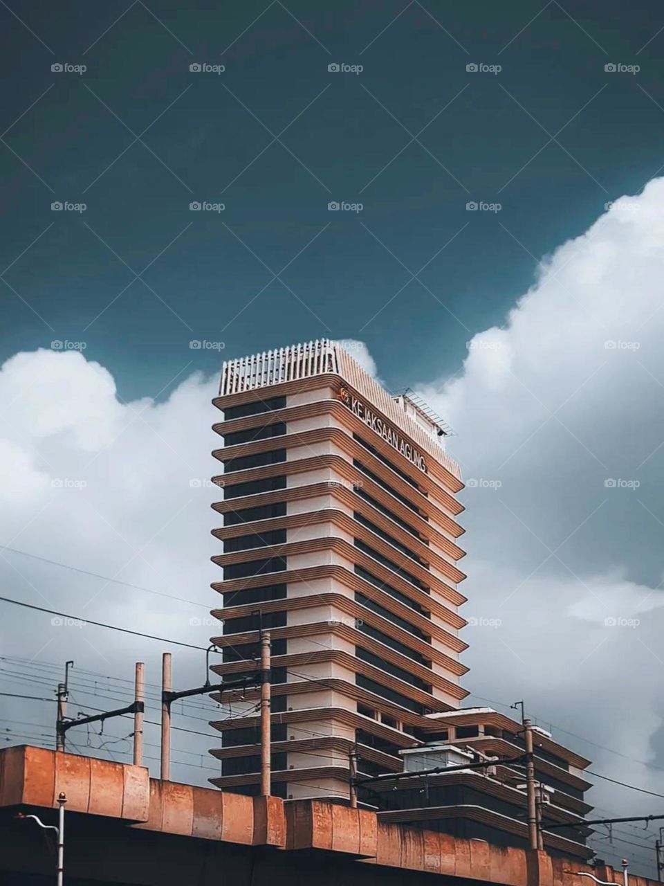 Long distance view of a multi-storey building with a clear sky and white clouds as a background in low angle view