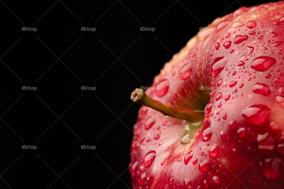 red whole  apple   glistering with dew water droplet.  Macro shot