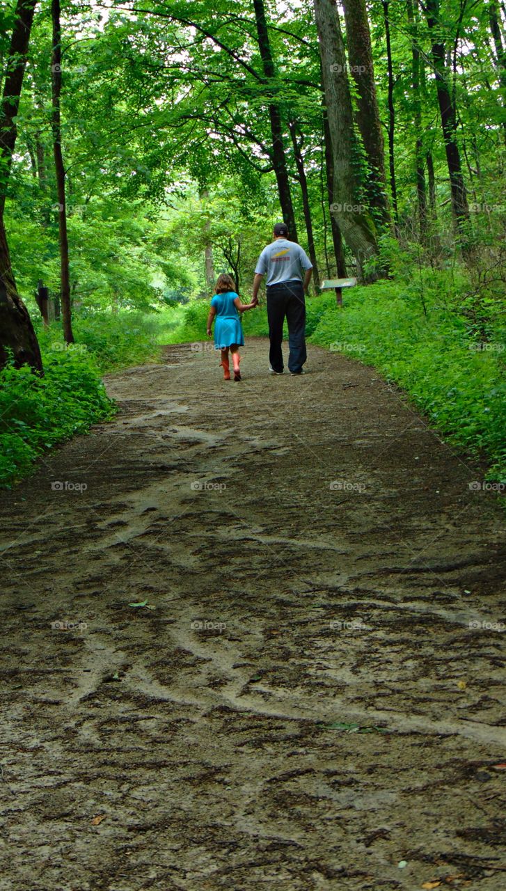Family hiking up muddy trail. 