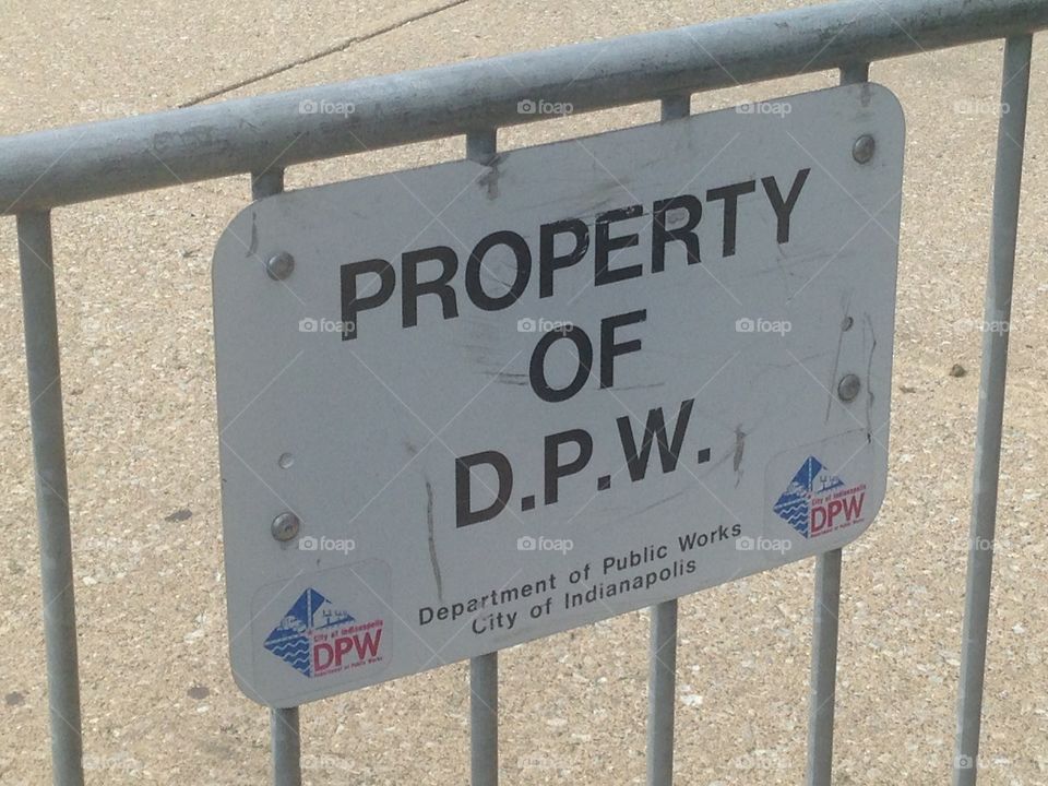 Sign hung from a fence owned by D.P.W.