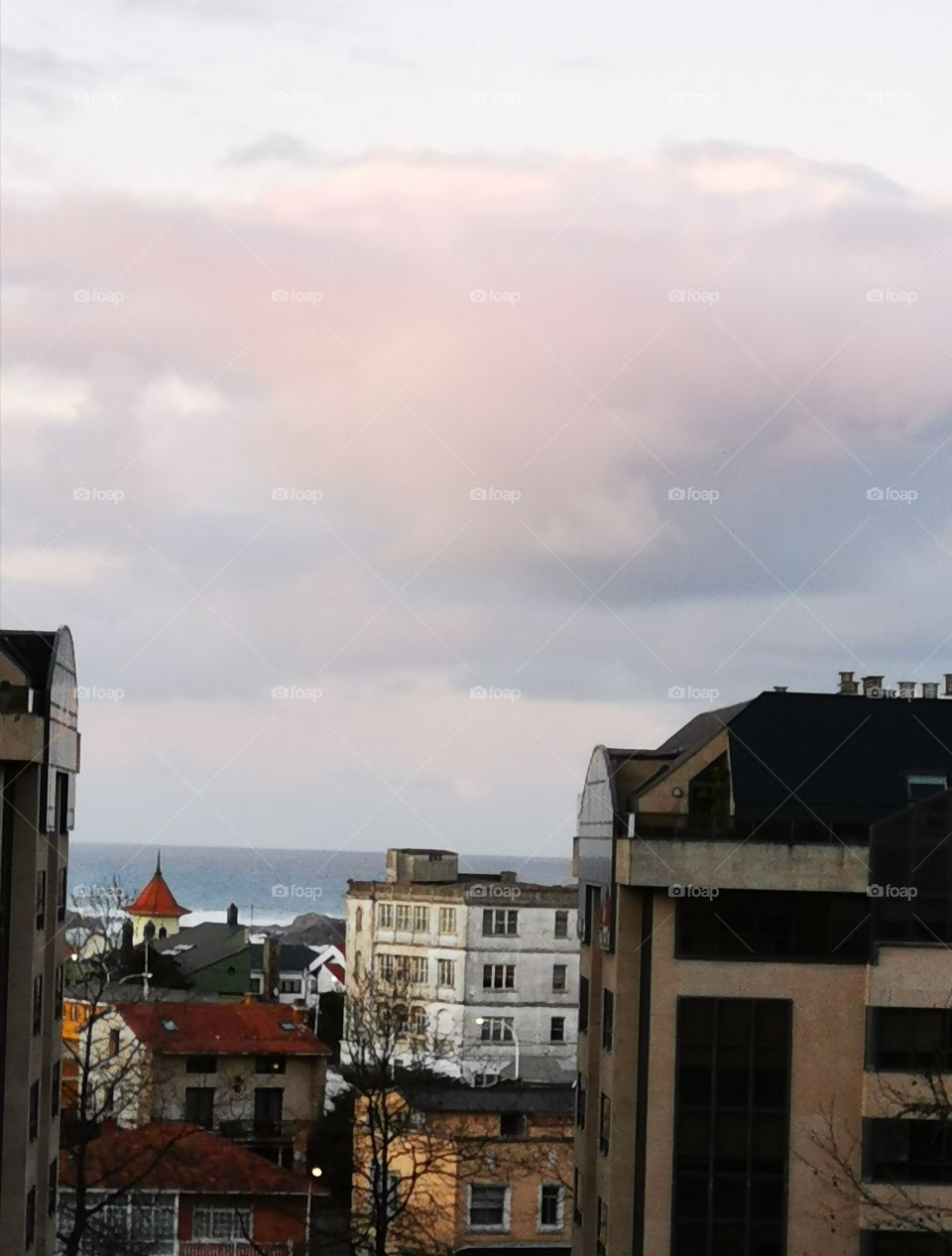 Al fondo de la ciudad se ve el. Ar un poco anaranjado por la nube anaranjada.