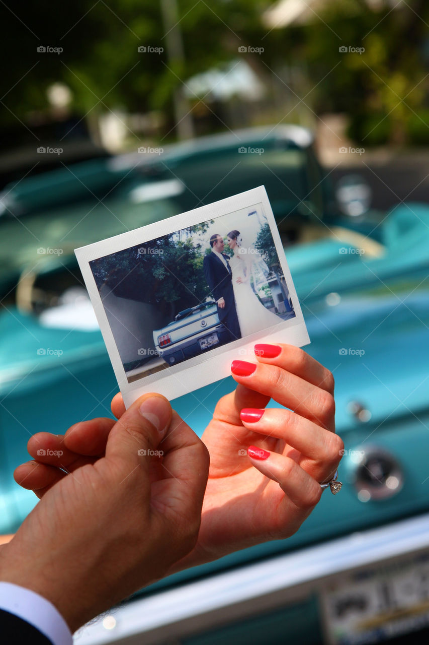 Young couple of new weds watching their polaroid instant picture