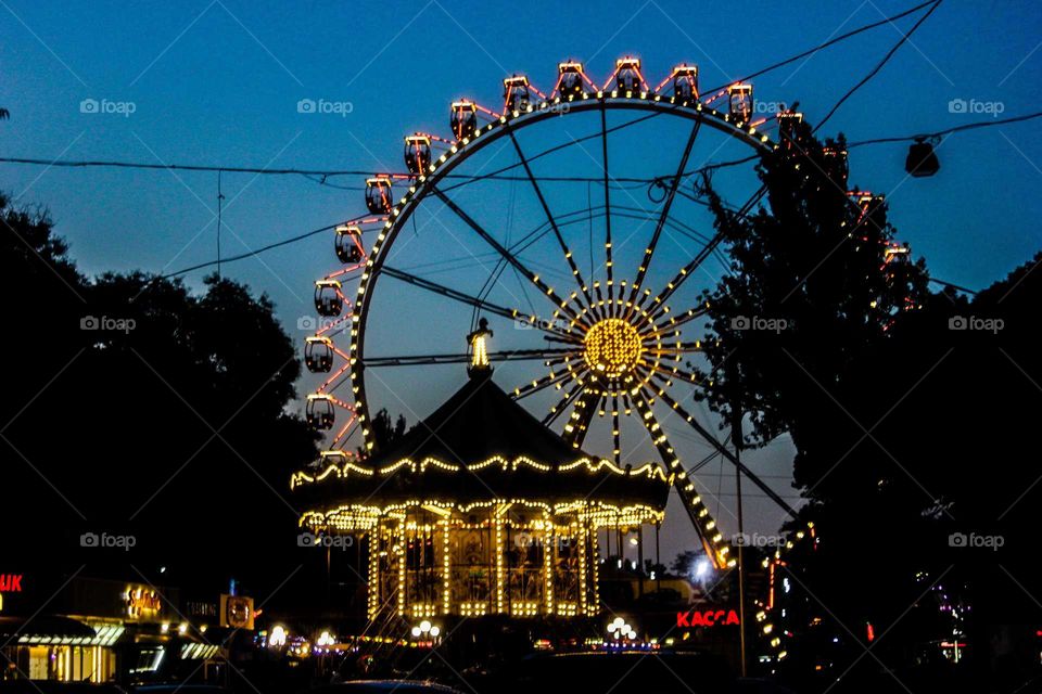 Carousel and illumination. Ferris wheel.