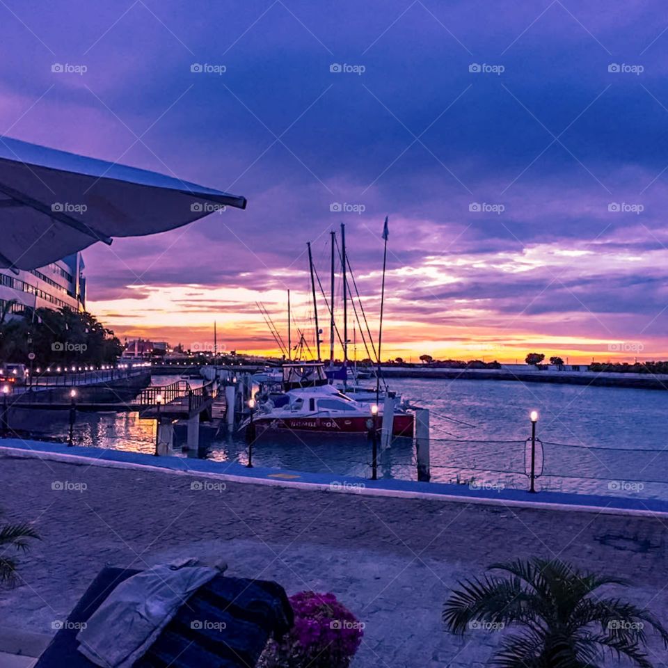 Sunset at the Marina in Fortaleza, Brazil. Beautiful view of the boats moored in the Marina at the end of the afternoon, with the last rays of the sun between the clouds of purple collaboration, reflecting on the shore.