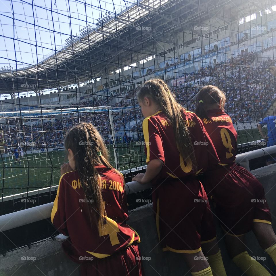 The girl football team are watching the match. 