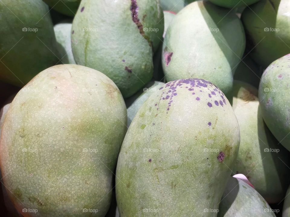 Some mango display at the market for sale.