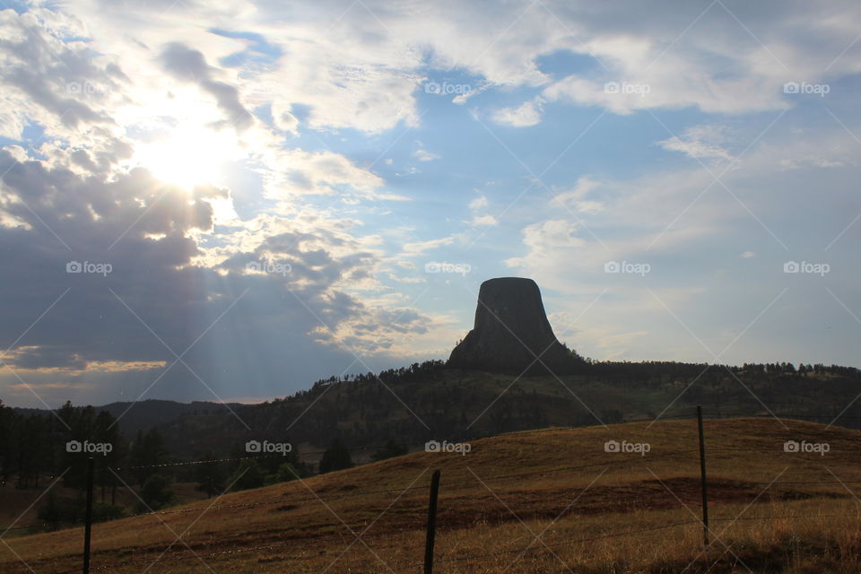 Devils tower dark summer daytime Blue skies Colors cloudy gloomy sunset gray skies outline beautiful landscape views scenic