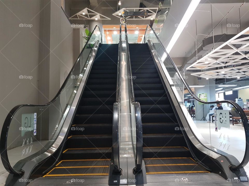 elevator in shopping building, bandung indonesia, escavator to go up side by side with escavator go to down, bounded by railings and glass, in shopping building, urban buildings