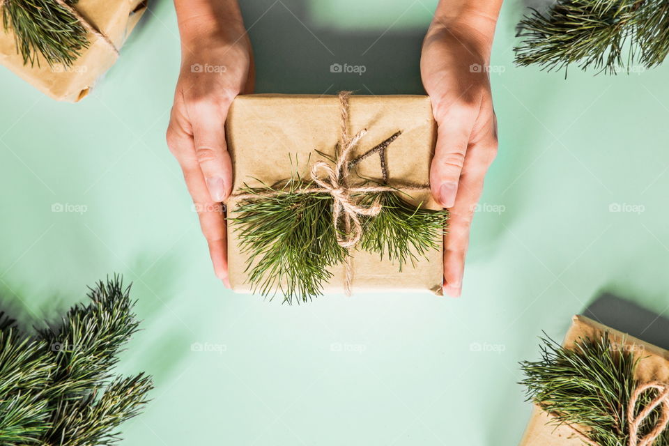 Female hands holding Christmas gift. Flatlay items. Flat lay, top view, surprise, happy new year, merry, tree, packing, packed, wrapping, celebrating, holidays, winter, background