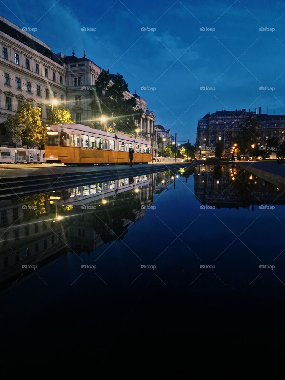 the reflection of the tram in the artesian fountain in Budapest