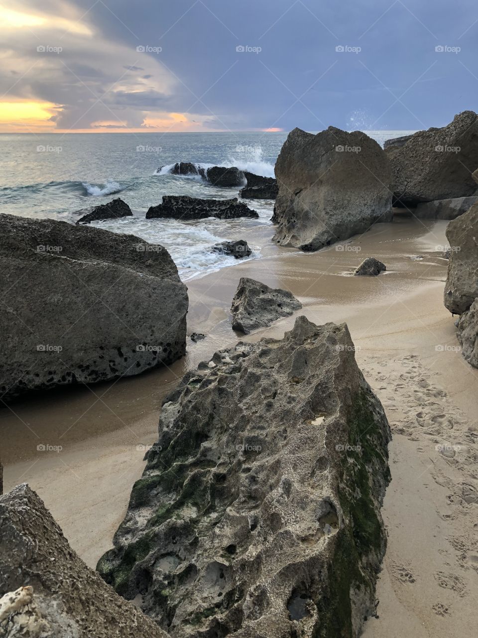 Atlantic Ocean waves break on the rocks at Nazaré, the sun is going down as a storm begins to roll in - no edits, no filter, #truephotos, true nature